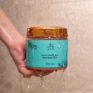 Naturally luxurious Hala Body Sugar Scrub by House of Soap being held in a shower